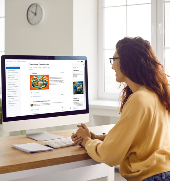 Woman sitting at computer using learning management system for training.