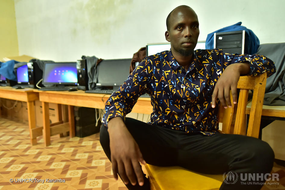 Young Somali refugee in room surrounding by computers