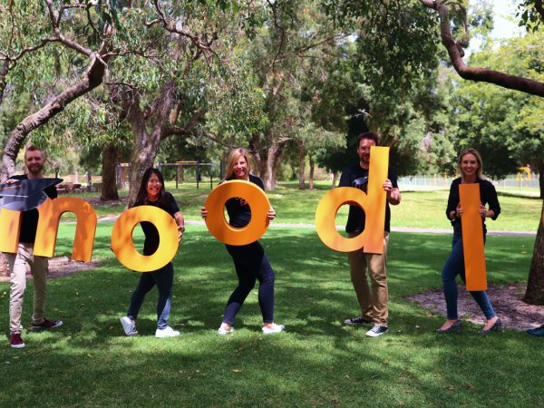 Moodle-Team mit riesigen „Moodle“-Buchstaben Bild