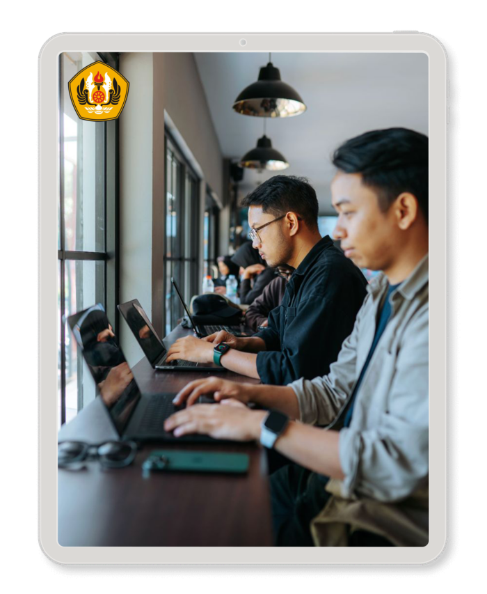 Students working on laptops in front of windows in a university.